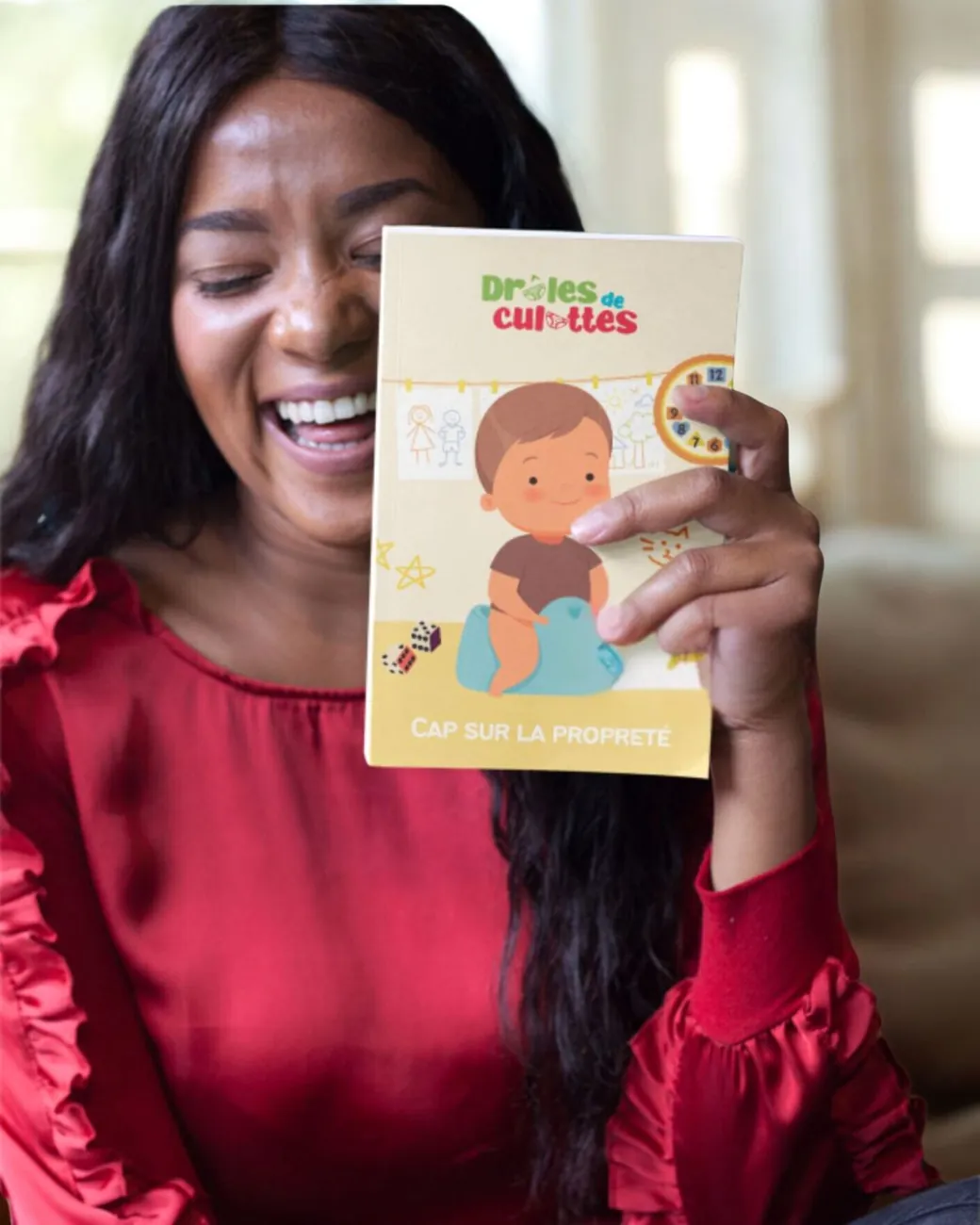 Maman souriante tenant le guide Cap sur la propreté de Drôles de Culottes