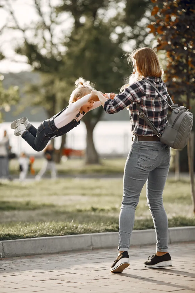 Parent et enfant complices dans un parc, communication Scoleo